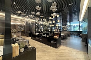 Un intérieur moderne doté d’un espace d’exposition central, de sièges et d’un plafond orné de luminaires suspendus.