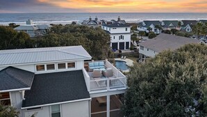 Zona residencial costera con casas, una piscina y vistas al océano.