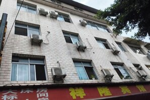 A multi-story building with multiple air conditioning units attached to the exterior. - Xiang Long Hotel (Guanghan)