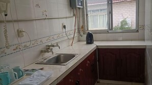 A kitchen with a sink, cabinets, and a window. - Xiang Long Hotel (Guanghan)