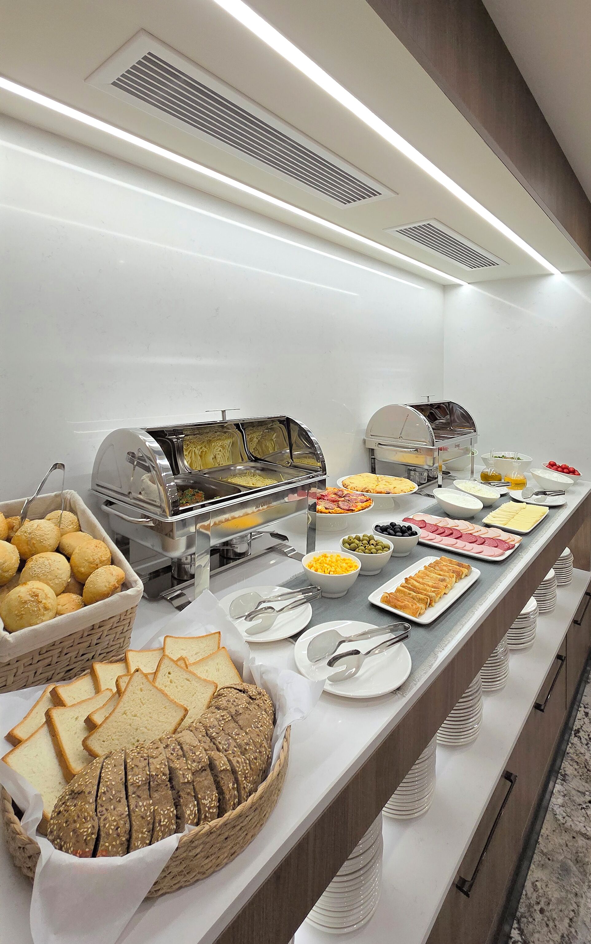 Een buffet met diverse soorten eten, zoals brood, kaas en vlees.