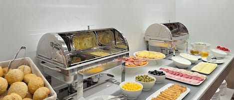 Een buffet met diverse soorten eten, zoals brood, kaas en vlees.