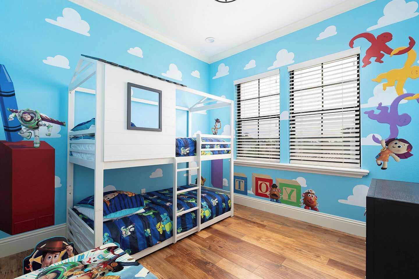 A child's bedroom with bunk beds, a window with blinds, and a wall with cloud and animal decals.