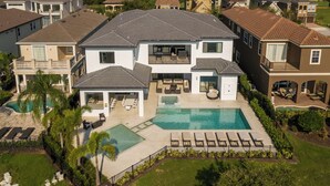 A large two-story house with a swimming pool, outdoor seating, and a well-maintained lawn. - The Superhero Haven-TT276 (Kissimmee)