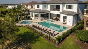 A modern two-story house with a swimming pool, outdoor seating, and a well-maintained lawn. - The Superhero Haven-TT276 (Kissimmee)