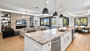 A modern kitchen with granite countertops, a central island, and a dining area with a large window.