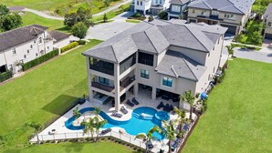 A multi-story house with a swimming pool and outdoor seating area.