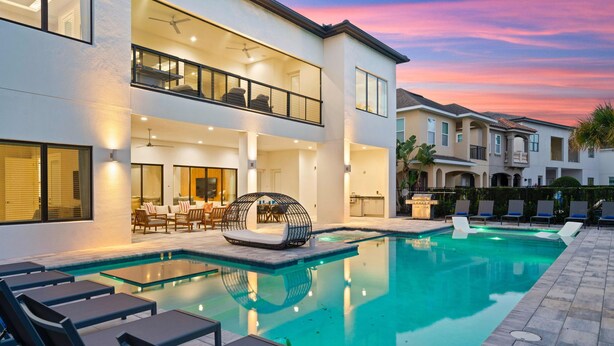 Un bâtiment moderne  à deux étages doté d’une piscine, d’un espace extérieur aménagé et d’un patio.