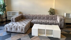 A modern living room with a sectional sofa, a white coffee table, and two pendant lights. - Coffee Inn Hostel Berlin (Berlin)