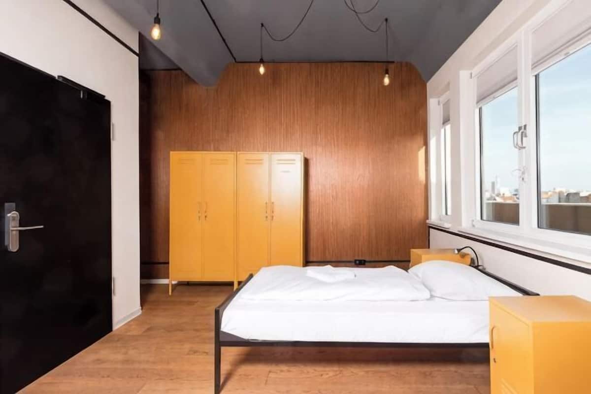 A bedroom with a bed, wardrobe, and window.