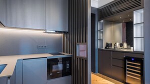 A modern kitchen with built-in appliances, a wooden countertop, and a large window. - Highline Downtown Aparthotel (Bucharest)