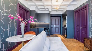 A modern interior with a sofa, a round table, and a vase with flowers. - Highline Downtown Aparthotel (Bucharest)