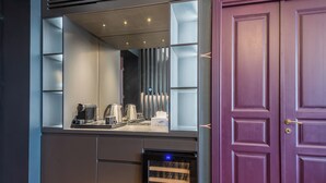 A modern kitchen with a built-in coffee station, a dishwasher, and a purple door. - Highline Downtown Aparthotel (Bucharest)