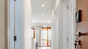 A hallway with white walls and a wooden door on the right. - Styling 5 BR Duplex Apartment (First 6th of October)