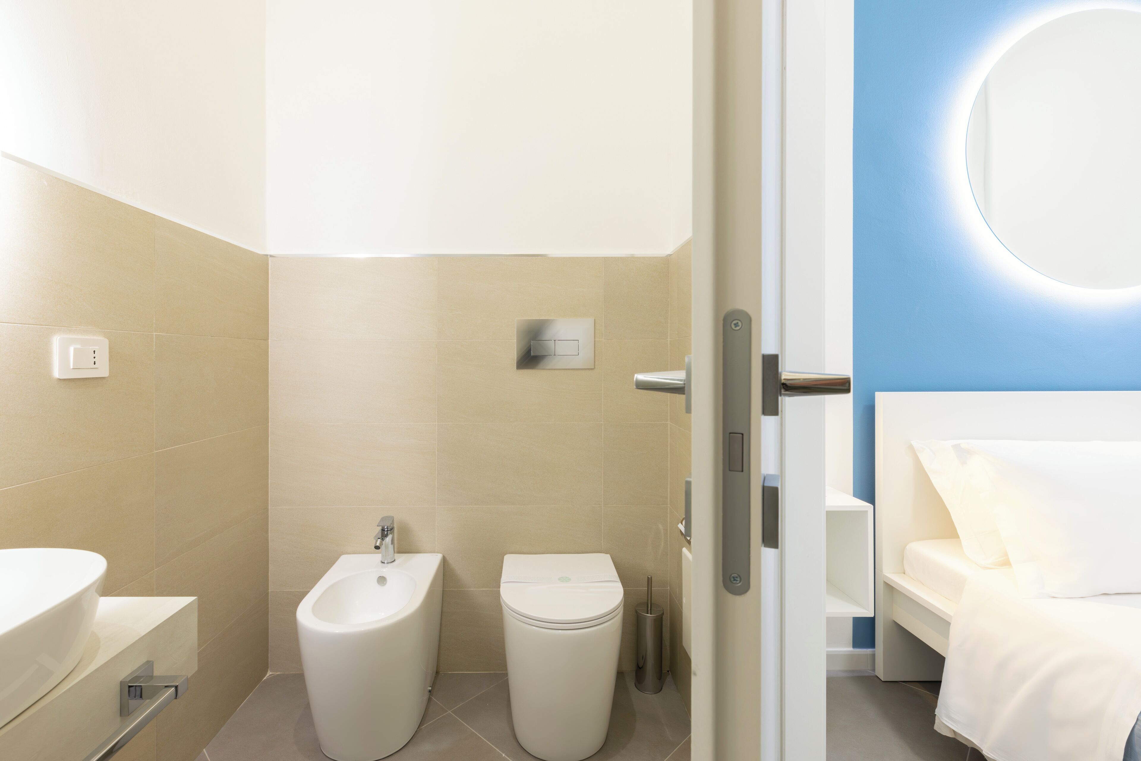 A modern bathroom with a bidet, toilet, and sink.