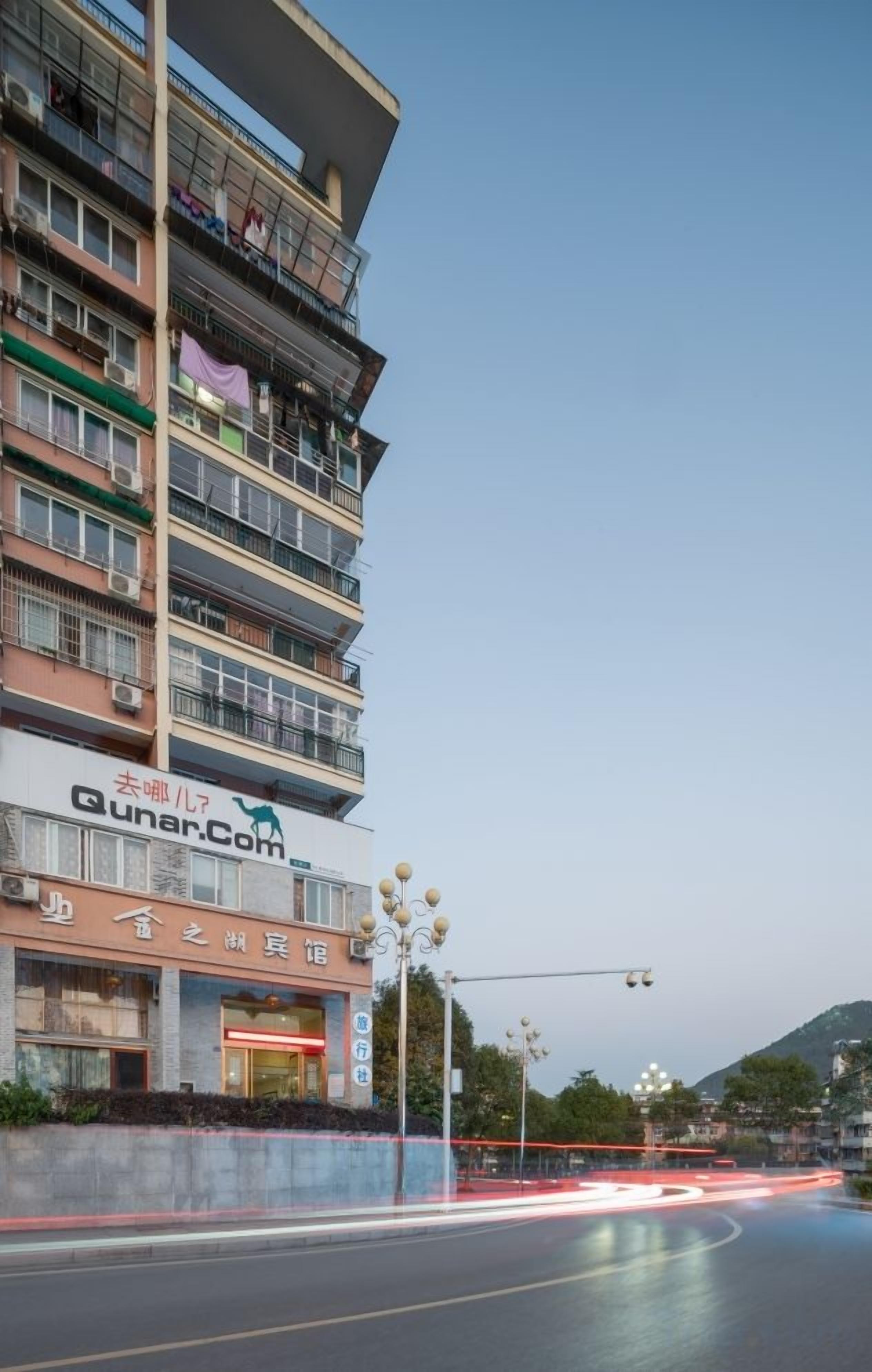 A multi-story hotel with balconies and a visible sign for 'Qunar.Com'.