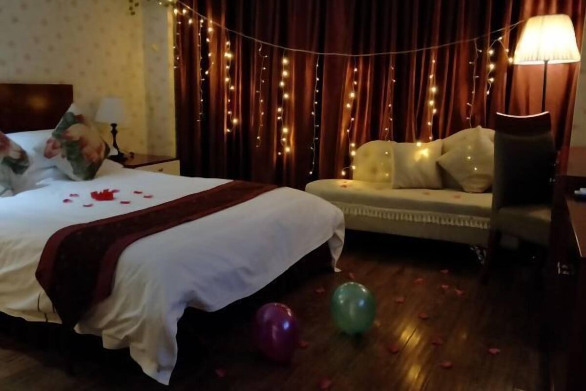 Een hotelkamer met een bed, een bank, een lamp en lichtslingers.