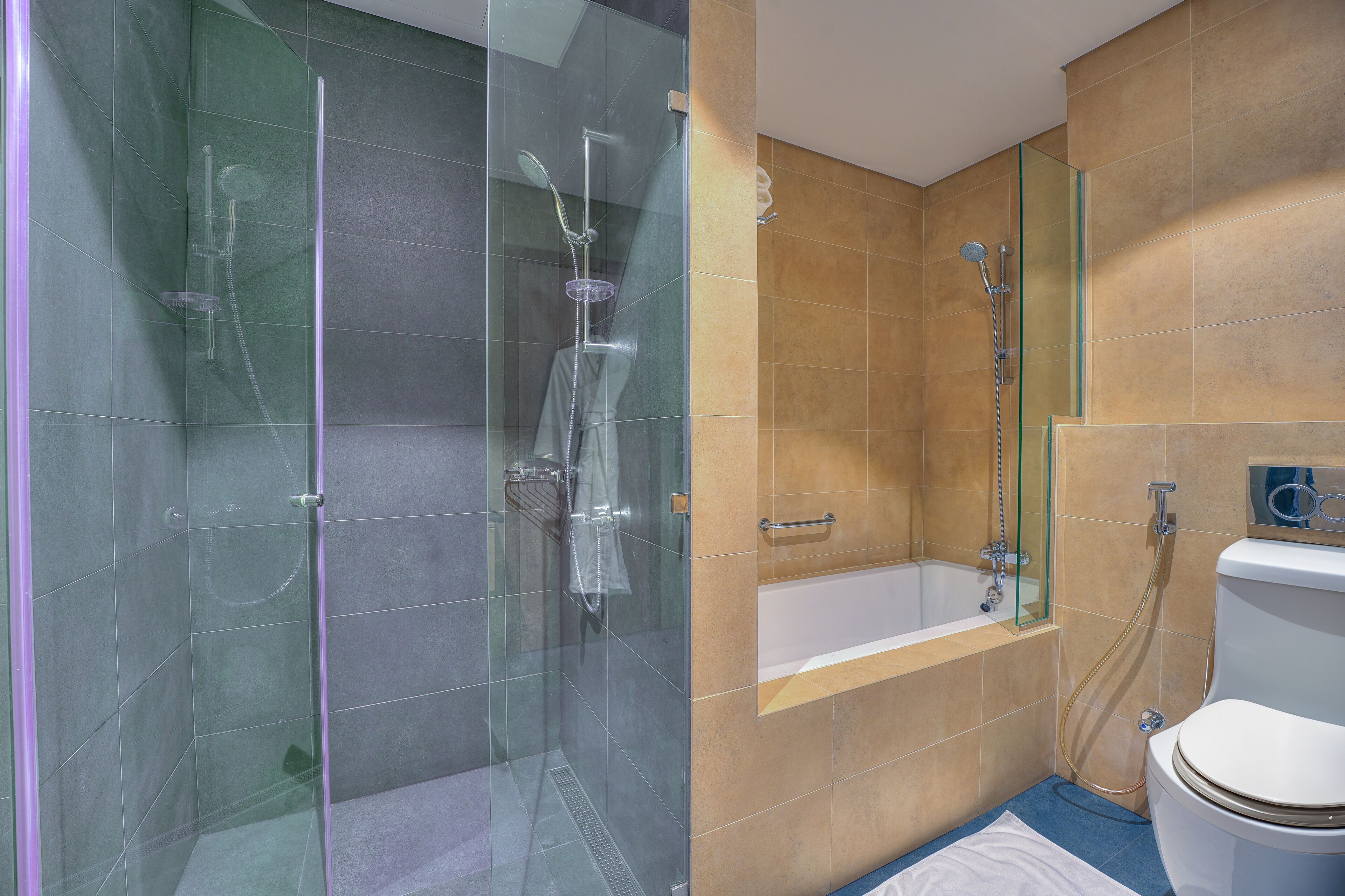 A modern bathroom with a glass-enclosed shower, a bathtub, and a toilet.