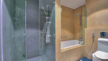 A modern bathroom with a glass-enclosed shower, a bathtub, and a toilet.