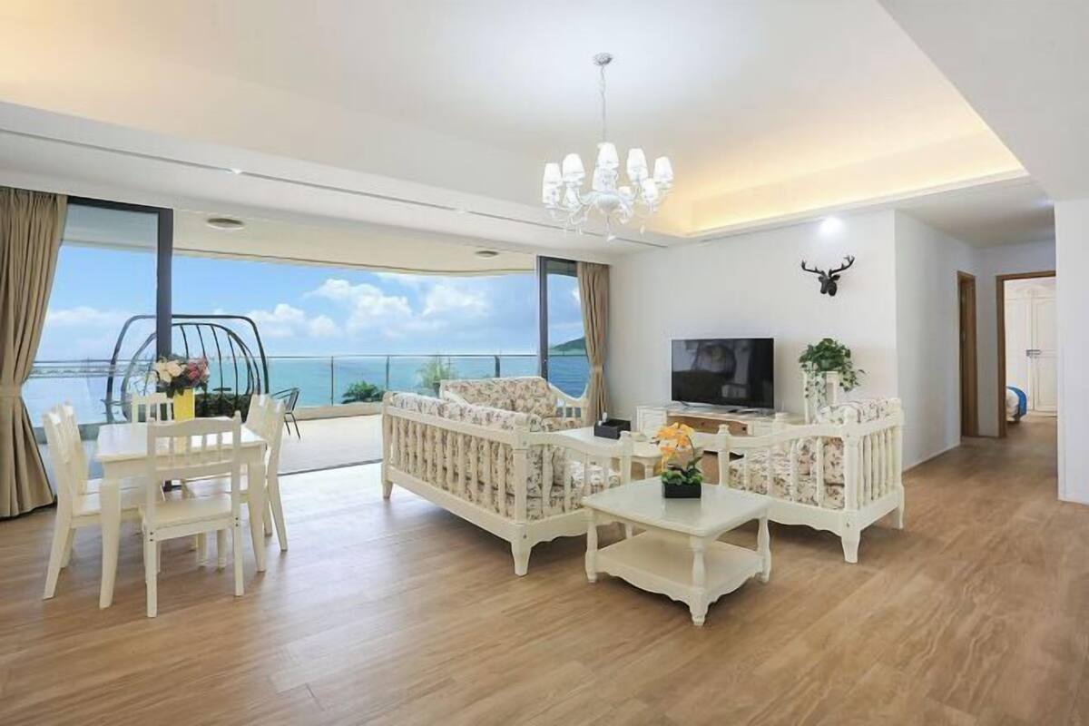 A modern living room with a sofa, TV, and dining area.