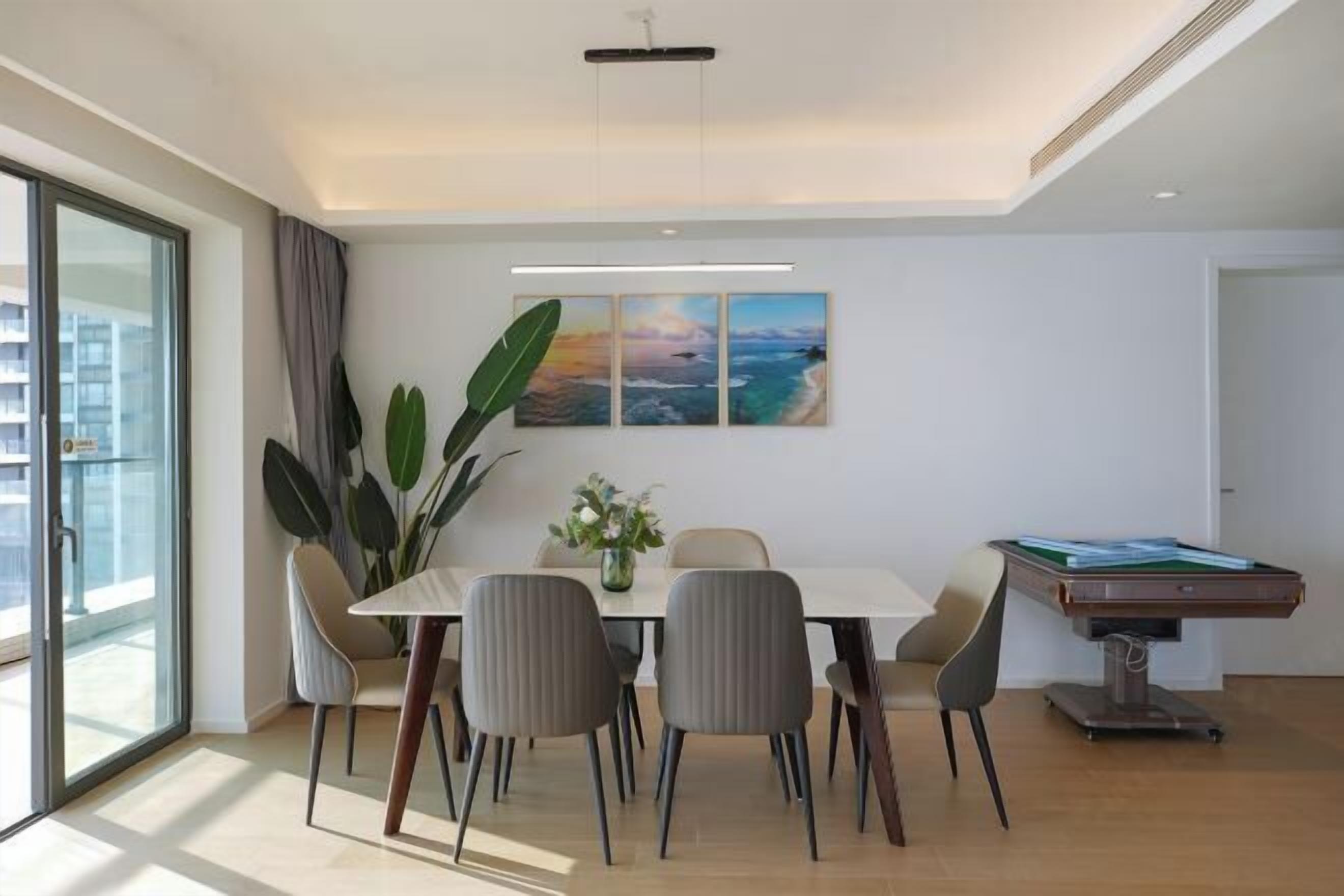 A modern dining area with a table, chairs, and a pool table.