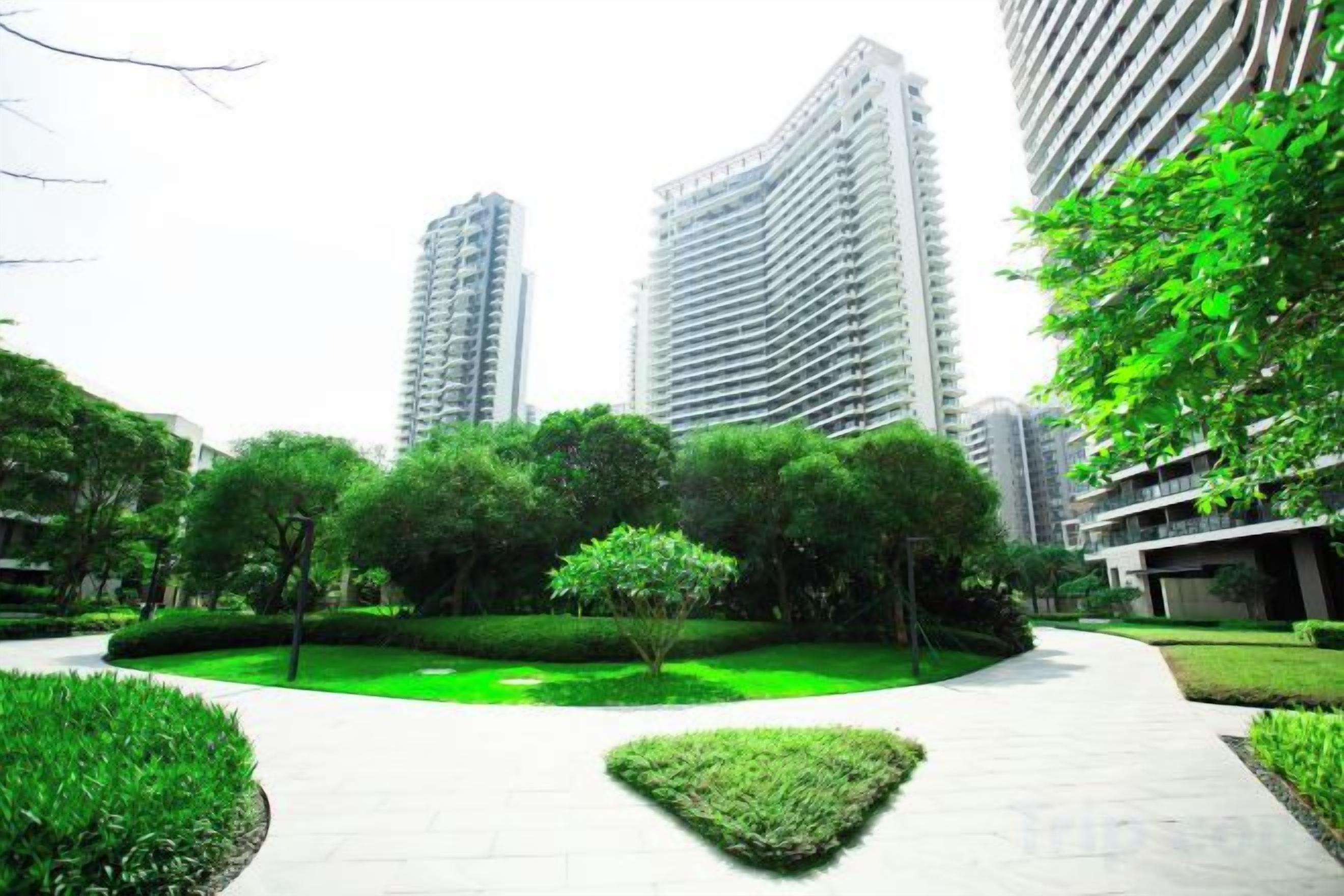 A pathway in a park-like setting with tall buildings in the background.