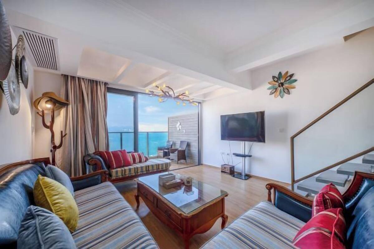 A modern living room with a sofa, coffee table, and a flat-screen TV.