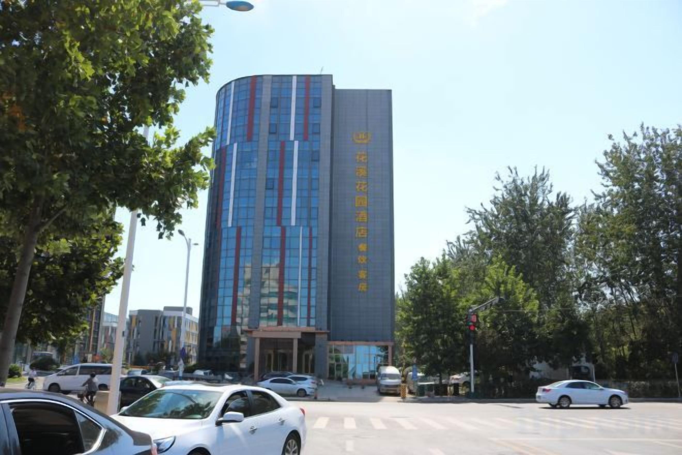 Ein modernes Gebäude mit einer geschwungenen Fassade, mehreren Stockwerken und einem gut erkennbaren Eingang.