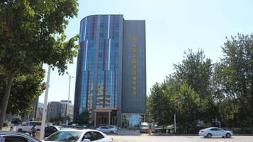 A modern building with a curved facade, multiple floors, and a clear entrance.