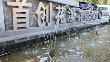 A water feature with a stone wall and Chinese characters.
