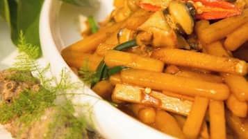 Un tazón de vegetales salteados con tofu y garbanzos, adornado con hierbas.