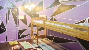 A room with a bunk bed, geometric wall design, and a chandelier. - Yuzons Bedspacer and Transient Home Staycation (Parañaque)