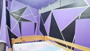 A room with a bed, purple walls, and geometric wall patterns. - Yuzons Bedspacer and Transient Home Staycation (Parañaque)