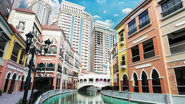 A canal with buildings on either side, a bridge, and a clear sky. - Yuzons Bedspacer and Transient Home Staycation (Parañaque)