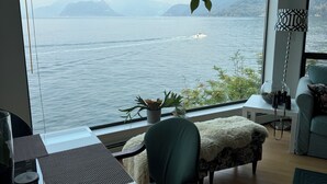 A room with a large window overlooking a lake and mountains, a dining table, a sofa, and a lamp. - ⭐️ 😍10% discount for the previous guests!😍 ⭐️ 

Sunset view- Ocean front!😍🌹 (West Vancouver)