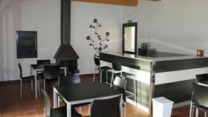 Una cocina moderna con una isla central, sillas negras y una pieza de arte decorativo en la pared.