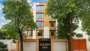 A hotel named "Golden Era" with a modern facade, large windows, and a gated entrance. - Hotel Golden Era (Noida)