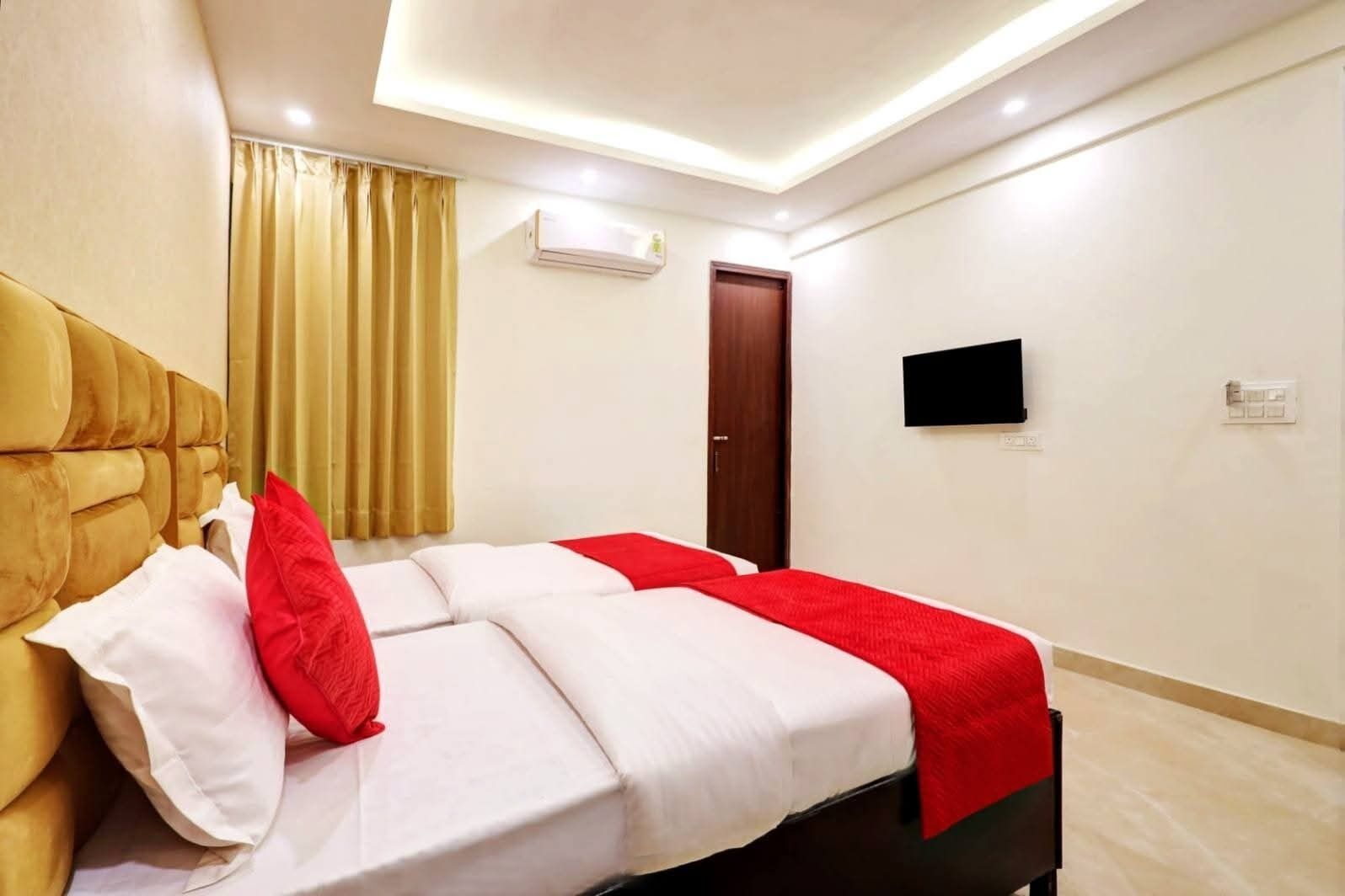 Een hotelkamer met een bed, een televisie, een airconditioning en een deur.