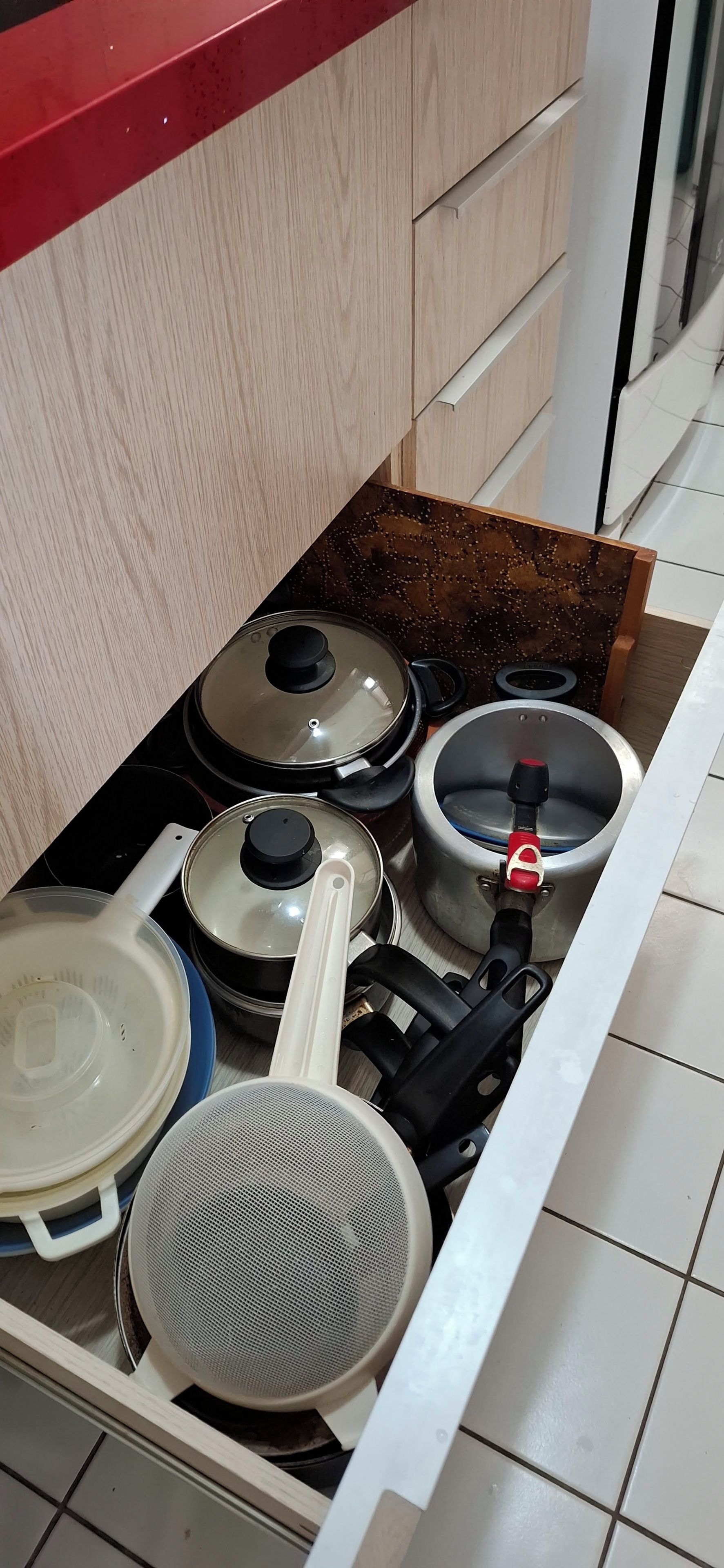 Un tiroir de cuisine contenant divers ustensiles et casseroles.