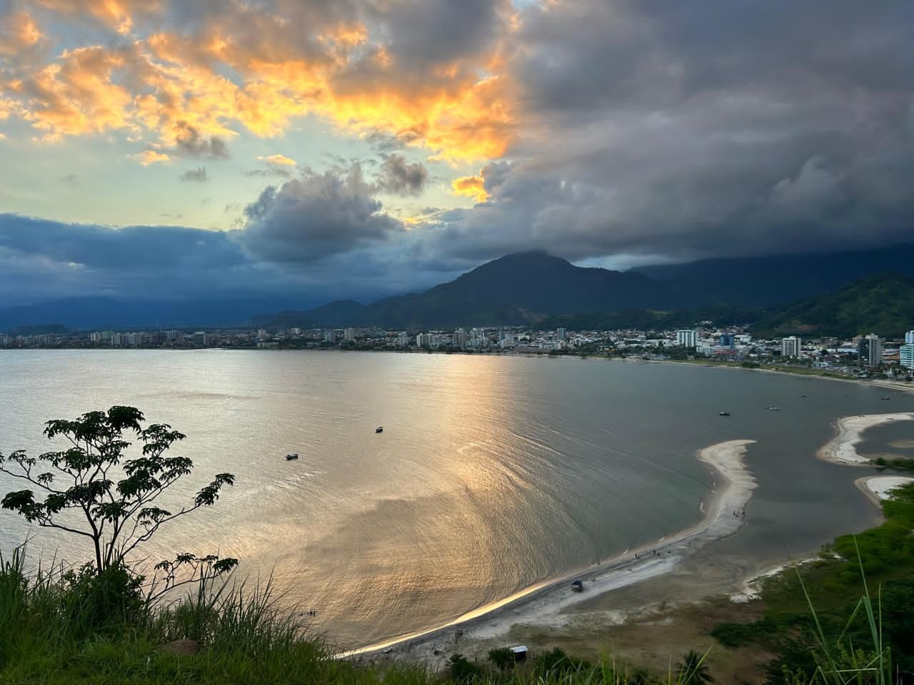 A coastal landscape with a body of water, a beach, and a city in the background.
