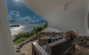 A balcony with a view of the sea, a table with food, and a chair. - Mount Hartman Bay Estate- Main House (Lance aux Epines)