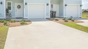 A two-story house with a front porch, garage doors, and a driveway.