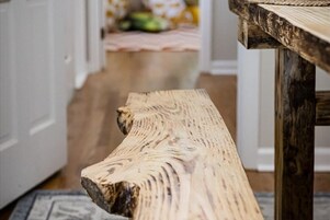 A wooden bench with a natural finish in a room with a wooden floor and white walls.