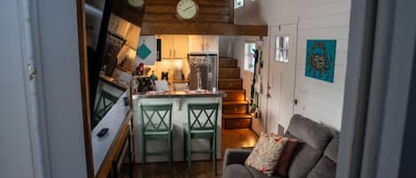 A cozy interior with a kitchen, dining area, and a living room with a couch.