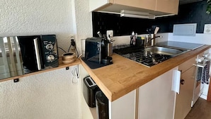 A compact kitchen with a built-in microwave, toaster, and sink. - Vue imprenable sur les Alpes (Crans-Montana)