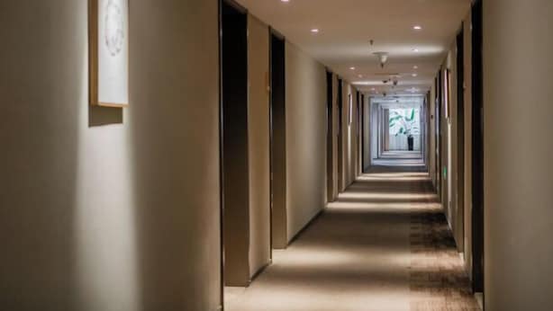 A long, narrow hotel corridor with doors on both sides, recessed lighting, and a carpeted floor. - Homeinn · neo (Hangzhou Xiaoshan Train South Station Tonghuizhong Road Subway Station) (Hangzhou)