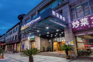 A hotel with a glass entrance, signage for 'Hotel Inn,' and a storefront with a sign that reads 'Shao Cai.' - Homeinn · neo (Hangzhou Xiaoshan Train South Station Tonghuizhong Road Subway Station) (Hangzhou)