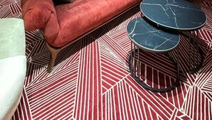 Una sala de estar moderna con un sofá rojo, un sillón blanco y una mesa de centro negra.