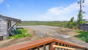 A rural road with a wooden fence and a small shed on the left. - Oceanfront suite for 2 (Hampton)
