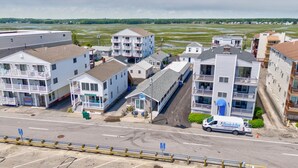Un hôtel situé sur la côte, composé de plusieurs bâtiments, dont un restaurant en bord de mer et un espace piscine.